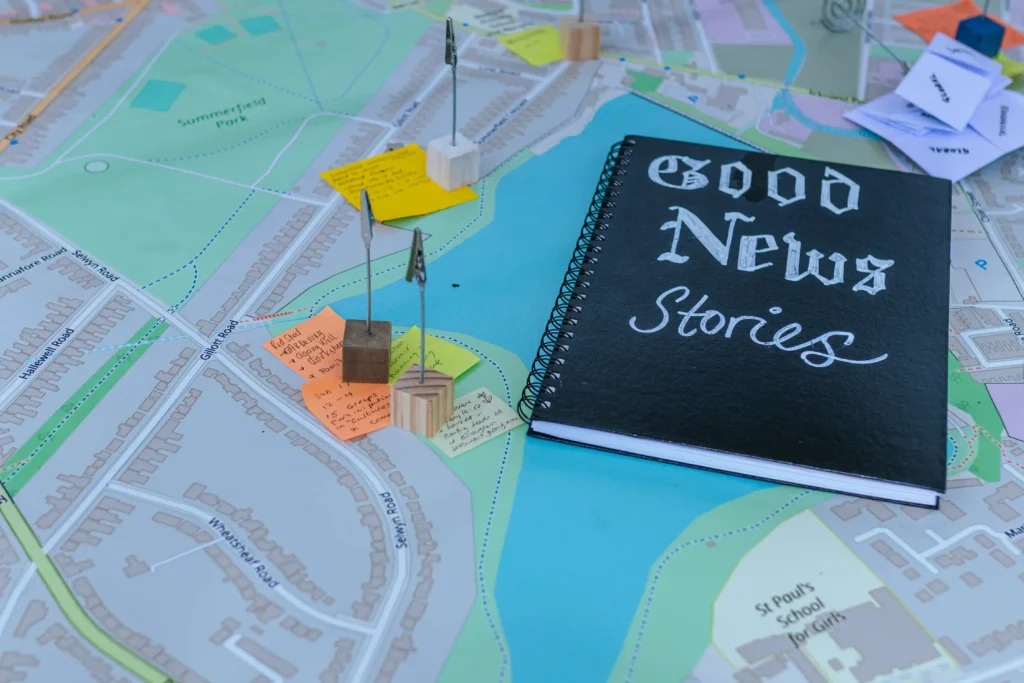 Notebook with "Good News Stories" on a map showing streets and a park, relevant to place-based retrofit.
